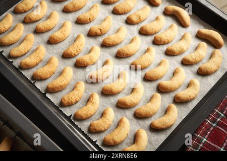 Pasta dolce appena sfornata su una teglia da forno - mezzaluna di vaniglia fatte in casa o Kipferl, tradizionali biscotti natalizi Foto Stock