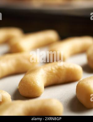 Mezzaluna di vaniglia cruda o Kipferl, biscotti di Natale tradizionali, su carta da forno, primo piano Foto Stock