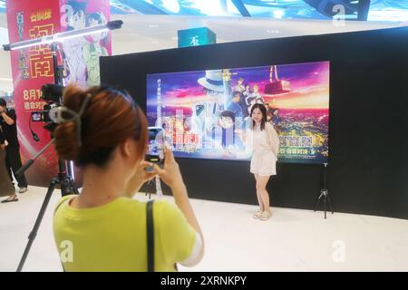 SHANGHAI, CINA - 10 AGOSTO 2024 - i fan dell'animazione e i blogger di celebrità di Internet si mettono in posa per un selfie Cosplay con foto di poster durante la premiere Foto Stock