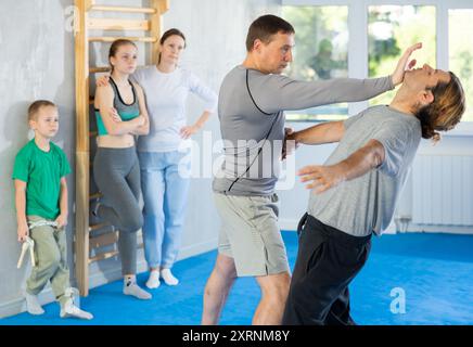 L'uomo in palestra esegue elementi di base del sistema di autodifesa krav maga. Foto Stock