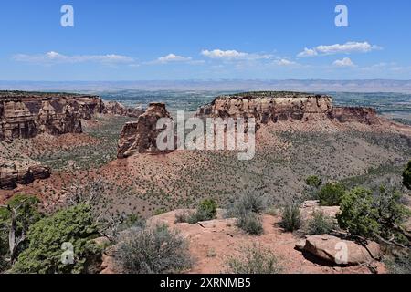 Vista panoramica del Colorado National Monument nelle giornate estive limpide e soleggiate con la città di Fruita, Colorado visibile sullo sfondo. Foto Stock