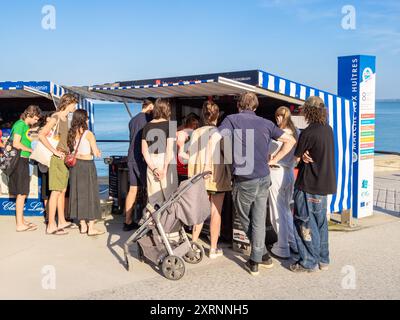 Cancale, Francia - 19 luglio 2024: Le persone all'ostrica si trovano sul mare a Cancale, Bretagna. Foto Stock