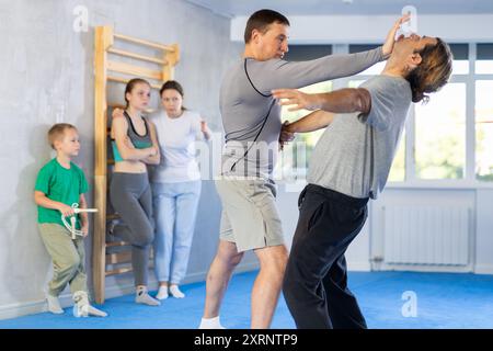 L'uomo in palestra esegue elementi di base del sistema di autodifesa krav maga. Foto Stock