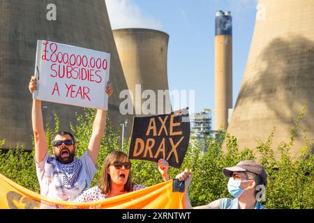 Selby, Regno Unito. 11 AGOSTO 2024. I dimostranti hanno una varietà di segnali, in quanto circa 50 manifestanti riuniti per manifestare contro la centrale elettrica Drax, affermano che le stazioni che utilizzano "pellet di legno" come sostituto del carbone causano la deforestazione di massa, ciò accade quando a Drax è stata concessa un'ingiunzione contro i manifestanti del clima e 22 membri del gruppo Recorder The Power sono stati arrestati preventivamente prima di un pianificato squat di più giorni a Drax. Credito Milo Chandler/Alamy Live News Foto Stock