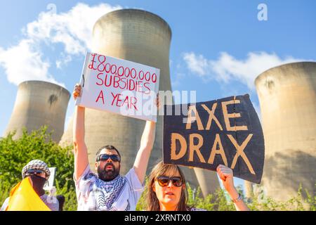 Selby, Regno Unito. 11 AGOSTO 2024. I dimostranti hanno una varietà di segnali, in quanto circa 50 manifestanti riuniti per manifestare contro la centrale elettrica Drax, affermano che le stazioni che utilizzano "pellet di legno" come sostituto del carbone causano la deforestazione di massa, ciò accade quando a Drax è stata concessa un'ingiunzione contro i manifestanti del clima e 22 membri del gruppo Recorder The Power sono stati arrestati preventivamente prima di un pianificato squat di più giorni a Drax. Credito Milo Chandler/Alamy Live News Foto Stock