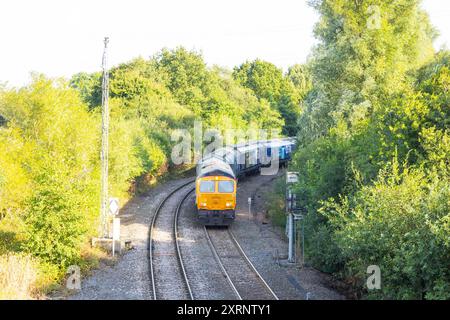 Selby, Regno Unito. 11 AGOSTO 2024. L'unità ferroviaria GBRF 66308 entra nel Drax mentre circa 50 manifestanti riuniti per dimostrare contro la centrale elettrica Drax, affermano che le stazioni che utilizzano "pellet di legno" in sostituzione del carbone provocano la deforestazione di massa, ciò accade quando a Drax è stata concessa un'ingiunzione contro i manifestanti del clima e 22 membri del gruppo Recorder The Power sono stati arrestati preventivamente prima di un pianificato squat di più giorni a Drax. Credito Milo Chandler/Alamy Live News Foto Stock