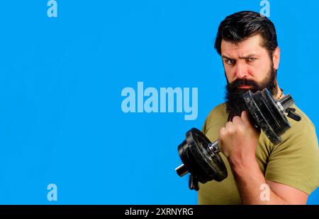 Uomo serio in abbigliamento sportivo che solleva il manubrio. Bel modello di fitness maschile atleta che solleva il manubrio in palestra. Gli sportivi forti fanno il sollevamento pesi. Muscoloso Foto Stock