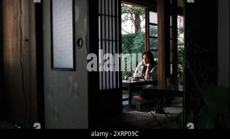 La ragazza beve un tè in estate all'interno della tradizionale casa washitsu in Giappone Foto Stock