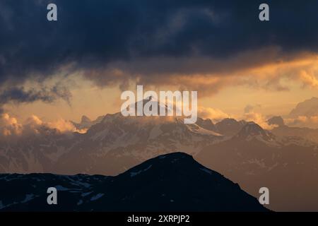 Tramonto emozionante, ombre e luce solare calda sulla cima Piazzi e sulle montagne, cielo spettacolare. Nuvole straordinarie. Alpi. Europa. Foto Stock