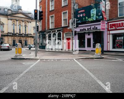 All'incrocio del centro città, i semafori segnalano la strada, in quanto i veicoli rimangono assenti dalla strada. Gli edifici nelle vicinanze mostrano una distinta arcaica Foto Stock