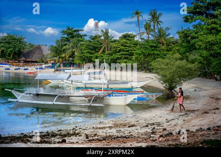 Barche tradizionali ormeggiate sulla spiaggia di Logon, sull'isola di Malapascua, Cebu, Filippine, la spiaggia più famosa di Malapascua è Bounty Beach, a sud di Th Foto Stock