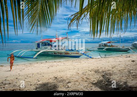 Barche tradizionali ormeggiate al largo di una piccola spiaggia tropicale dell'isola di Kalanggaman, Malapascua, Cebu, Filippine Foto Stock