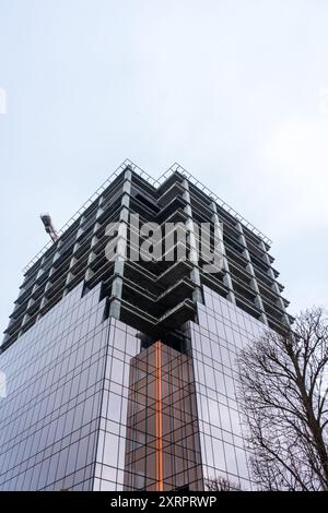 Installazione di finestre a doppi vetri in un edificio a più piani in un cantiere Foto Stock