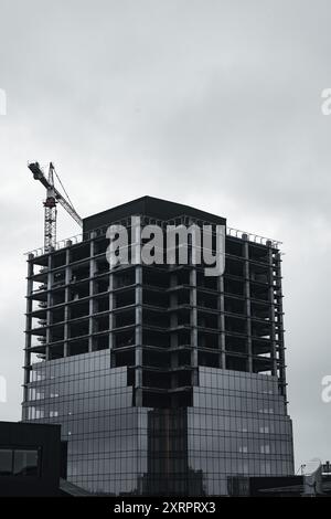 Installazione di finestre a doppi vetri in un edificio a più piani in un cantiere Foto Stock