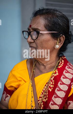 Old Old Old Lady indiana con occhiali da vista che indossano Saree gialle. Asia meridionale induista religiosa anziana donna in abito tradizionale sari. Foto di strada, viaggio p Foto Stock