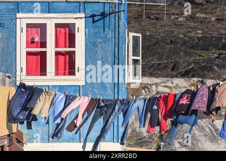 Asciugatura dei vestiti su una linea di lavaggio nel vento di fronte a una casa, insediamento inuit, Ittoqqortoormiit, Groenlandia orientale, Groenlandia Foto Stock