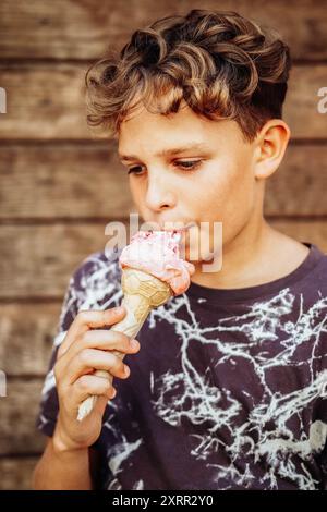 Ragazzo che mangia un delizioso gelato in una giornata calda Foto Stock