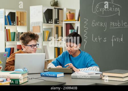 Due ragazzi che usano il computer nella libreria Foto Stock
