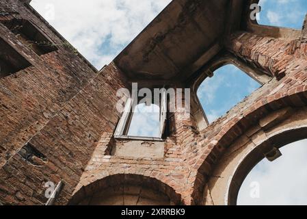 Edificio storico in rovina con cielo blu e nuvole bianche. Fotografia interna in mattoni color crema che guarda a Witley Court. Foto Stock
