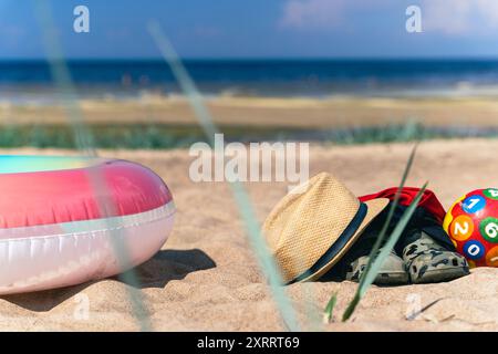 Giocattoli e accessori da spiaggia su una spiaggia sabbiosa Foto Stock