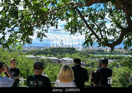 (240812) -- PECHINO, 12 agosto 2024 (Xinhua) -- i turisti scattano foto del Parco Beihai dalla collina di Jingshan in una giornata di sole a Pechino, capitale della Cina, 12 agosto 2024. (Xinhua/li Xin) Foto Stock