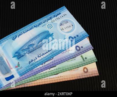 Banconote in valuta dei nuovi polimeri degli Emirati Arabi Uniti da cinque, dieci, cinquanta e cinquecento dirham su sfondo nero Foto Stock