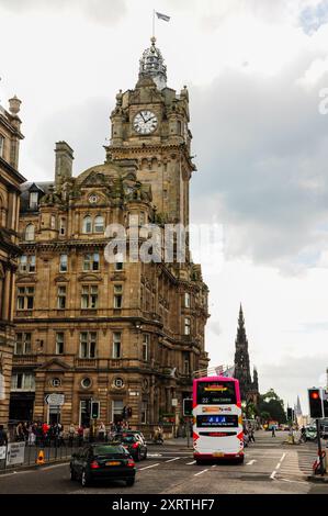 Vista della strada trafficata di Edimburgo con l'iconica torre dell'orologio e l'autobus a due piani. Foto Stock