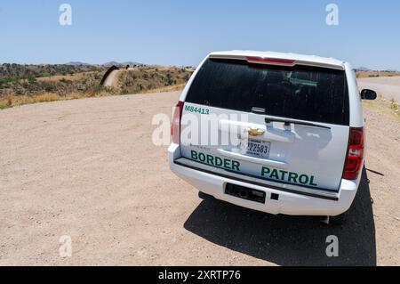 Un veicolo di pattuglia di confine vicino al confine tra Messico e Stati Uniti a Nogales, in Arizona, con il muro di confine a sinistra visibile, che divide entrambi i paesi Foto Stock