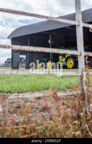 Un vecchio trattore immagazzinato in un fienile aperto in un'azienda agricola nel Regno Unito. Foto Stock