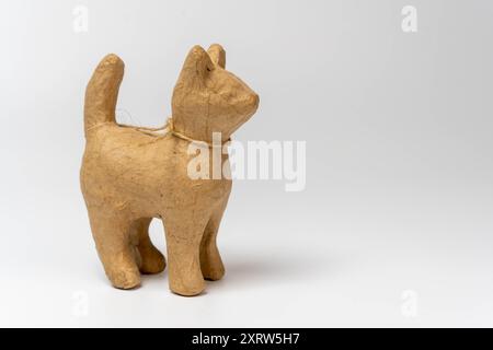 Una statuetta di gatto di carta marrone si erge su uno sfondo bianco. Foto Stock