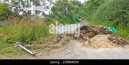 Carico di camion ribaltabile rifiuti assortiti scaricati ostruendo l'autostrada pubblica nello svincolo di corsia di campagna vicino a Brentwood Essex Countryside Inghilterra Regno Unito Foto Stock