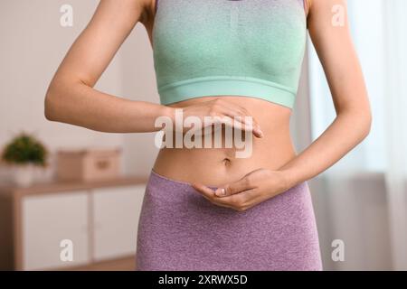 Digestione sana. Donna che tiene qualcosa vicino alla pancia dentro, primo piano Foto Stock