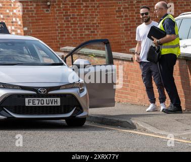 Brentwood Essex 12 agosto 2024 ci sono sempre più ritardi negli appuntamenti per i test di guida nel Regno Unito. A Brentwood, Essex, l'attesa media è di 24 settimane. Ciò sta causando notevoli difficoltà e costi per i conducenti degli studenti, è stato riferito che alcune aziende stanno utilizzando la tecnologia bot per bloccare i test dei libri che vengono poi rivenduti con un notevole profitto. Esaminatore del test di guida e istruttore di guida, credito: Ian Davidson/Alamy Live News Foto Stock