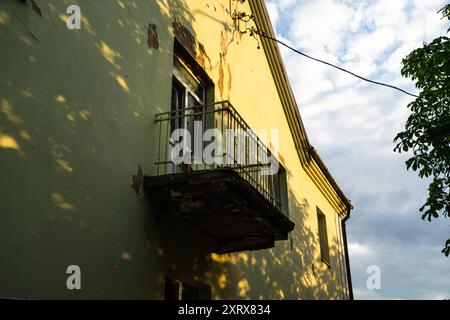 Balcone con accesso alla strada, in una vecchia casa, con intonaco sbucciato Foto Stock