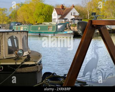 L'area intorno a Sandford Lock Over the Tamigi è un luogo molto apprezzato da chi pratica jogging, escursionisti, appassionati di cani e molti altri che frequentano le fantastiche passeggiate in questa zona. Un nuovo panettiere artigianale che offre pane a pasta madre di prima qualità è ora un'attrazione locale... Qui vediamo case galleggianti ormeggiate appena a monte della chiusa, presto in una bella giornata di primavera. Sto andando a prendere il pane... Foto Stock