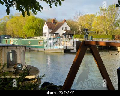 L'area intorno a Sandford Lock Over the Tamigi è un luogo molto apprezzato da chi pratica jogging, escursionisti, appassionati di cani e molti altri che frequentano le fantastiche passeggiate in questa zona. Un nuovo panettiere artigianale che offre pane a pasta madre di prima qualità è ora un'attrazione locale... Qui vediamo case galleggianti ormeggiate appena a monte della chiusa, presto in una bella giornata di primavera. Sto andando a prendere il pane... Foto Stock