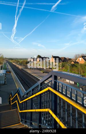 Radley è fortunato ad essere un piccolo villaggio con una stazione ferroviaria principale, che lo collega a Londra, Oxford e le Midlands. E qui, visto dal ponte della stazione sui binari, vediamo una linea di lampioni e una serie di telecamere di sicurezza che si affacciano sulla piattaforma. Il cielo primaverile è pieno di contrafforti che si estendono in blu. Foto Stock