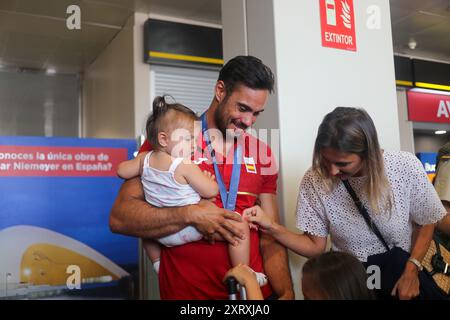 Santiago del Monte, Spagna, 12 agosto 2024: Il canoista Rodrigo Germade con la moglie e la figlia durante l'arrivo della squadra olimpica spagnola di canoa in Spagna, il 12 agosto 2024, all'Aeroporto delle Asturie, a Santiago del Monte, in Spagna. Crediti: Alberto Brevers / Alamy Live News. Foto Stock