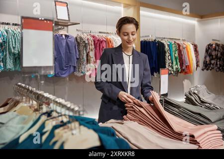 Giovane ed elegante donna d'affari che fa shopping nei grandi magazzini di abbigliamento Foto Stock