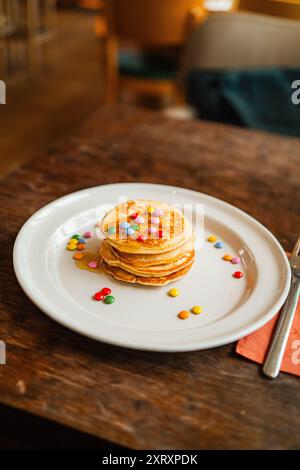 Condimento colorato e lucido su una pila morbida di pancake Foto Stock