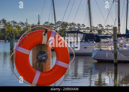 Manteo, Outer Banks, North Carolina, Stati Uniti d'America - 18 aprile 2024: Preserver dal vivo appeso su un palo di legno con un piccolo cartello con sopra Manteo nel porto. Foto Stock