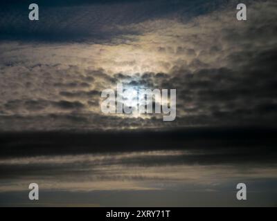 Sole alle prese con il paesaggio altocumulus sopra Radley Village. Mi piace guardare il cielo. Quello che vedi è spesso bello, e in continuo cambiamento; non vedi mai lo stesso cielo due volte. Camminando per la maggior parte dei posti, di solito sembro essere l'unica persona che guarda in alto; tutti gli altri sono a testa bassa, e si occupano dei loro affari quotidiani. Non sanno cosa si stanno perdendo... Come questo cielo spettacolare sopra casa mia a Radley Village, con il sole che sbircia fuori da uno splendido paesaggio altocumulus. Foto Stock