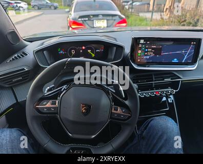 08 12 2024 - Kaunas, Lituania. Cabina di pilotaggio e cruscotto della nuovissima linea Peugeot 2008 GT. Tachimetro elettronico e display. Uomo seduto in macchina Foto Stock