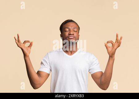 Tipo Zen calmo Afro che meditava in piedi, Studio Shot Foto Stock