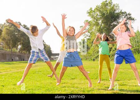 I bambini saltano e alzano le mani Foto Stock