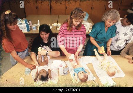 Austin Texas USA, 1994: Le ragazze delle scuole superiori usano le bambole per imparare a mettere un pannolino su un bambino durante la lezione di economia domestica alla Johnston High School. ©Bob Daemmrich Foto Stock