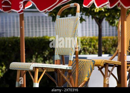 sedie da bistrot sotto gli ombrelli rossi Foto Stock