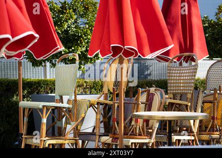 sedie da bistrot sotto gli ombrelli rossi Foto Stock