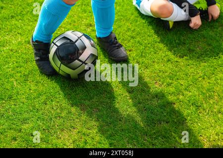 Black Football giocato da un giocatore di calcio vicino ai piedi dei giocatori Foto Stock