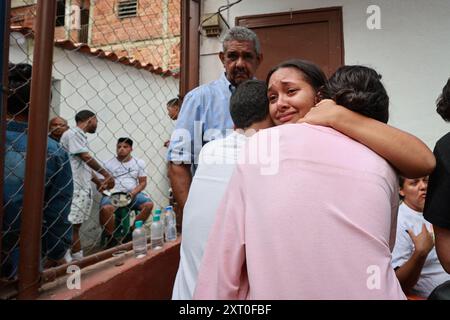 Caracas, Venezuela. 12 agosto 2024. I sopravvissuti si abbracciano dopo un'esplosione nel quartiere la Unión de Petare nello stato di Miranda, a est di Caracas. Ci sono state diverse vittime in Venezuela a seguito di un'esplosione di gas in un condominio. Credito: Jesus Vargas/dpa/Alamy Live News Foto Stock